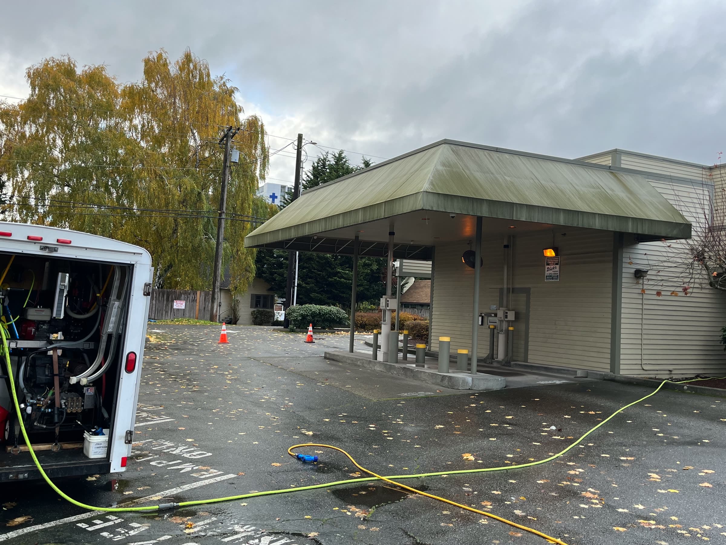 A bank drive-through canopy with a grimy roof and fascia, the open work trailer in the foreground.