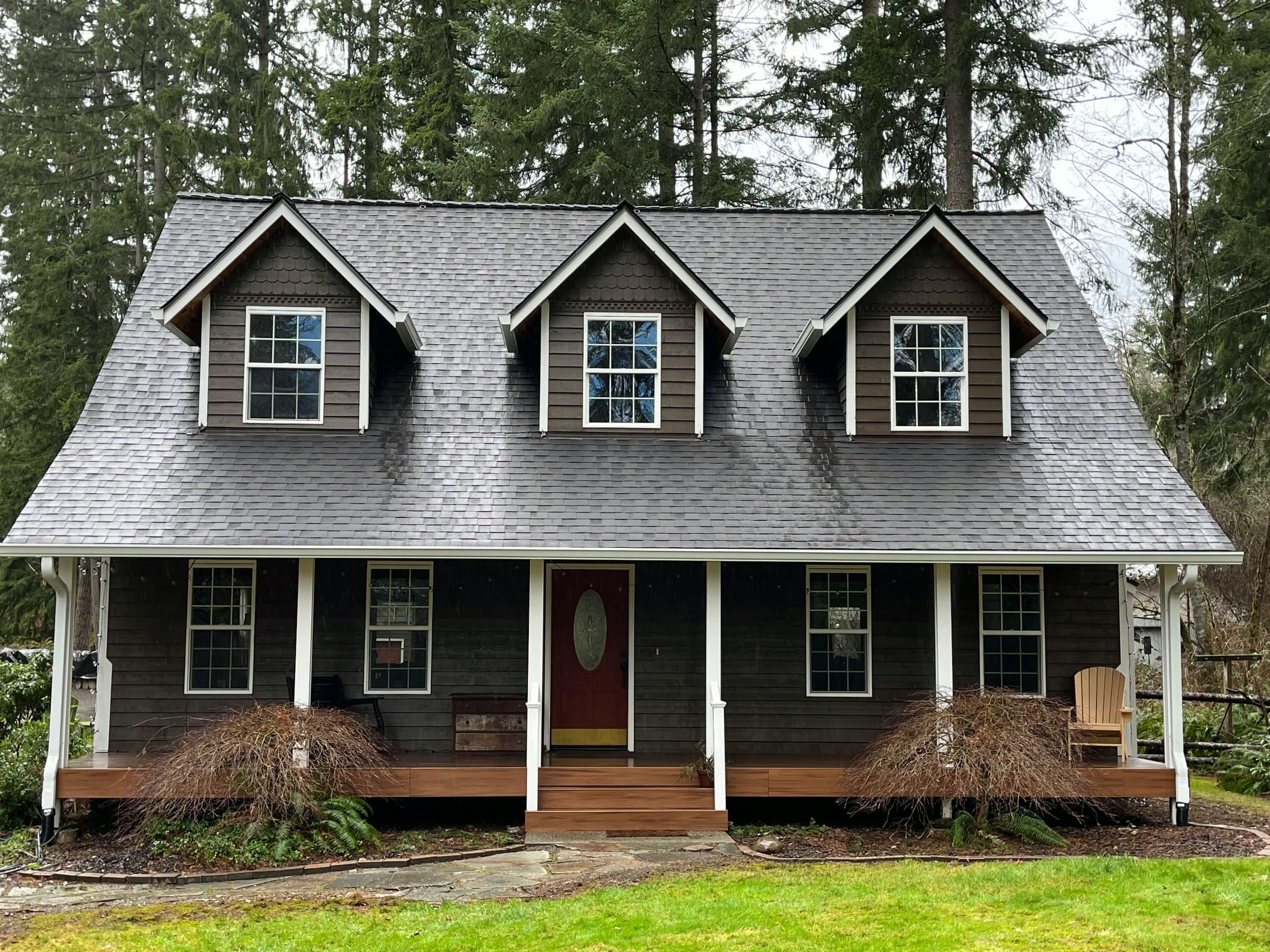 The same Cape Cod house after a soft wash, the roof clean and grey.