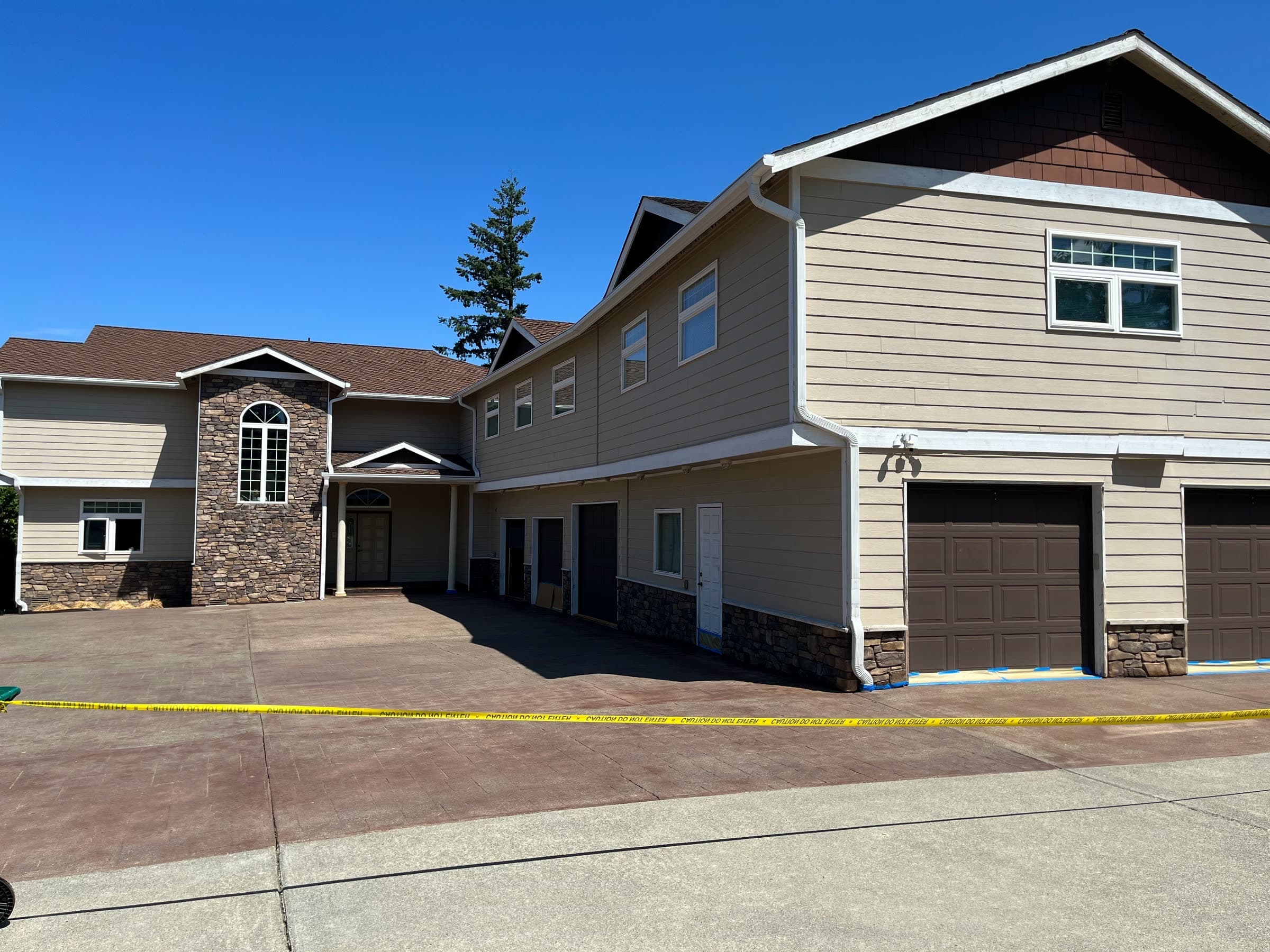 A row of two-storey townhouses with a clean stamped-concrete drive in front of the garages.